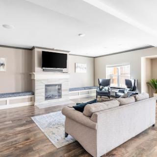 A stylish and modern living room featuring a cozy seating area, a fireplace, and ample natural light.