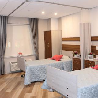 A well-designed hospital patient room featuring two beds, modern furnishings, and a bright atmosphere.