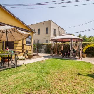 A sunny backyard with a patio set and gazebo.