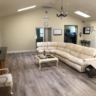 A spacious and modern living room featuring a large beige sectional couch and wooden flooring.
