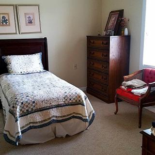 A cozy bedroom with a single bed and classic wooden furniture.