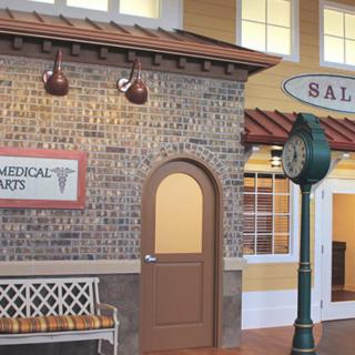 A quaint commercial building facade featuring a salon, with vintage brick walls and a classic street clock.