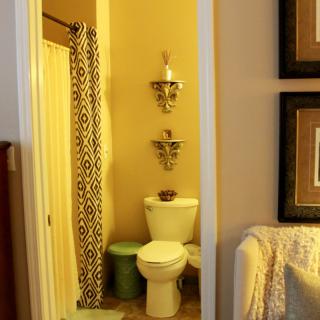 A cozy bathroom with decorative elements and a patterned shower curtain.