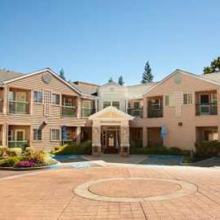 A two-story residential building with a courtyard and landscaped surroundings.