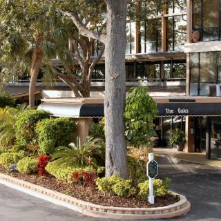 A hotel entrance surrounded by lush landscaping and trees.