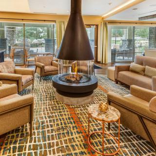 A modern and cozy living room with a central fireplace and comfortable seating.