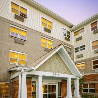 A residential apartment building with multiple windows and a prominent entrance.
