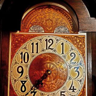 An ornate antique grandfather clock displaying the time.
