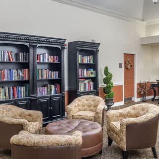 A cozy reading area with armchairs and bookshelves filled with books.