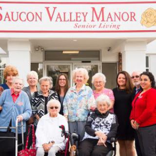 A group of seniors and caregivers standing outside Saucon Valley Manor.