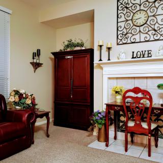 A cozy living room with elegant decor featuring a large clock above the fireplace.