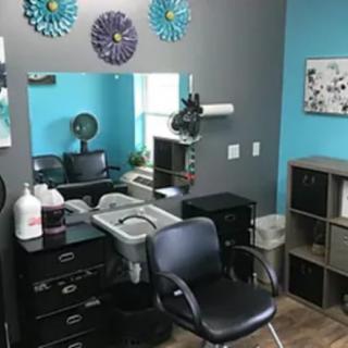 A well-organized hair salon station with a styling chair, mirror, and hair products.
