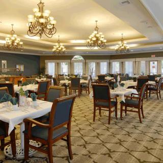 An elegant dining room with chandeliers and neatly arranged tables.