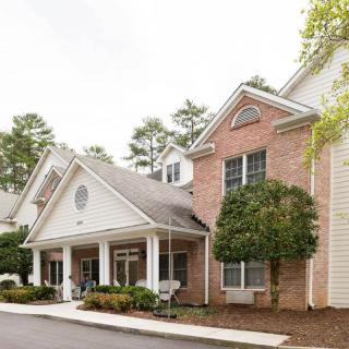 A charming residential building with a brick facade and well-maintained landscaping.