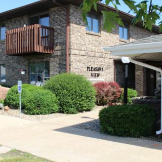 An exterior view of an apartment building with well-maintained landscaping.