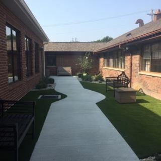 A serene courtyard with a winding pathway surrounded by greenery.