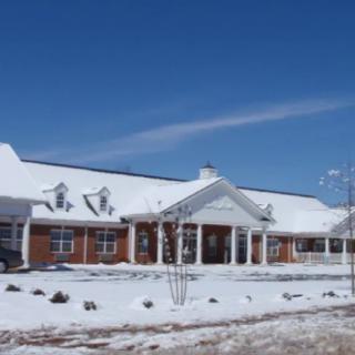 A snow-covered building with a brick facade on a clear winter day.