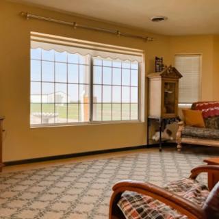 A cozy living room with a large window and comfortable seating.