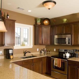 A modern kitchen with dark wood cabinets and stainless steel appliances.