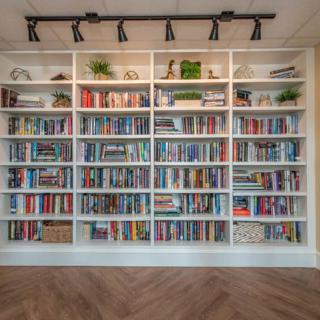 A neatly organized bookshelf filled with a diverse collection of books.