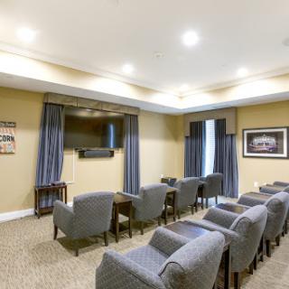 A well-furnished meeting room equipped with comfortable seating and a television, ideal for presentations and discussions.