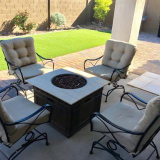 A cozy outdoor seating arrangement featuring a fire pit surrounded by comfortable chairs.