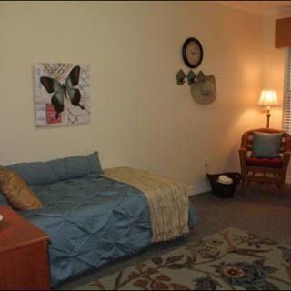 A cozy living room featuring a blue sofa, decorative artwork, and warm lighting.