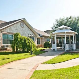 A charming house with a beautiful gazebo set in a lush garden.