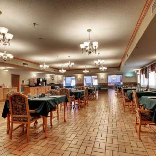 A spacious restaurant dining area with neatly arranged tables and elegant chandeliers.