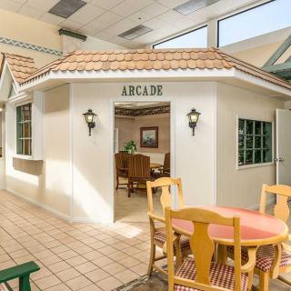 An indoor area with an arcade entrance, table, and chairs set in a brightly lit space.