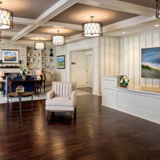 A modern lobby area featuring comfortable seating, decorative lighting, and artwork on the walls.