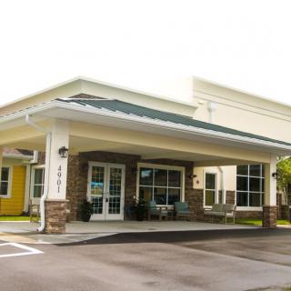 A commercial building with a covered entrance and large windows.