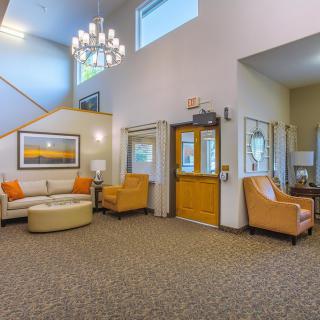 A modern lobby with comfortable seating, featuring a chandelier and contemporary decor.