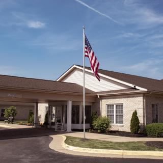 A building with an American flag at the entrance under a clear blue sky.