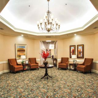 A well-decorated lobby with elegant furnishings and a central chandelier.