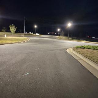 A dimly lit empty intersection at night.
