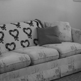 A cozy living room sofa adorned with pillows and a patterned blanket.
