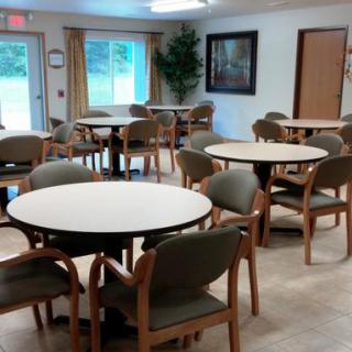 A community space with multiple tables and chairs arranged for meetings or dining.