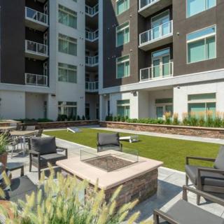 Modern apartment complex with outdoor patio and fire pit.