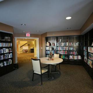 A cozy library corner with bookshelves, a small table, and chairs.