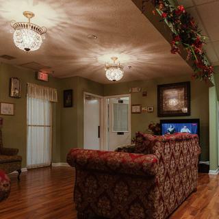 A cozy living room with a patterned sofa, wooden floor, and decorative lighting.
