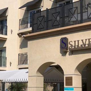 Exterior view of a residential apartment complex with balconies and signage.