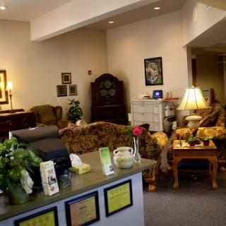 A cozy lobby area featuring comfortable seating, decorative plants, and warm lighting.