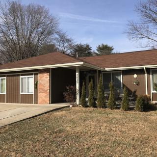 A suburban ranch-style house with a driveway and front lawn.