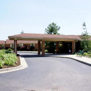 A welcoming entrance to a residential building with a well-maintained driveway and landscaping.