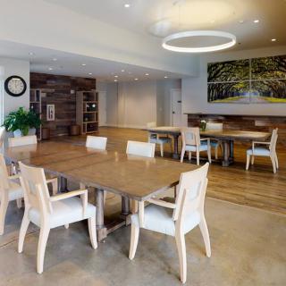 A modern dining area with wooden tables, chairs, and stylish lighting.