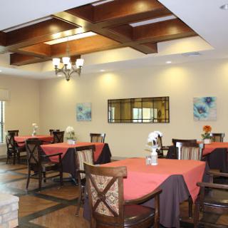 A cozy dining area featuring stylish tables and chairs, complemented by warm lighting and decorative artwork.