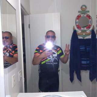 A cheerful selfie taken in the bathroom with a peace sign gesture.