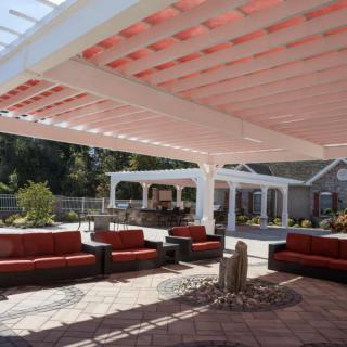 A stylish outdoor seating area with a pergola providing shade.