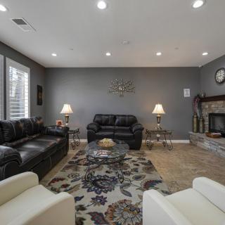 A modern living room with comfortable seating, a patterned carpet, and a cozy fireplace.